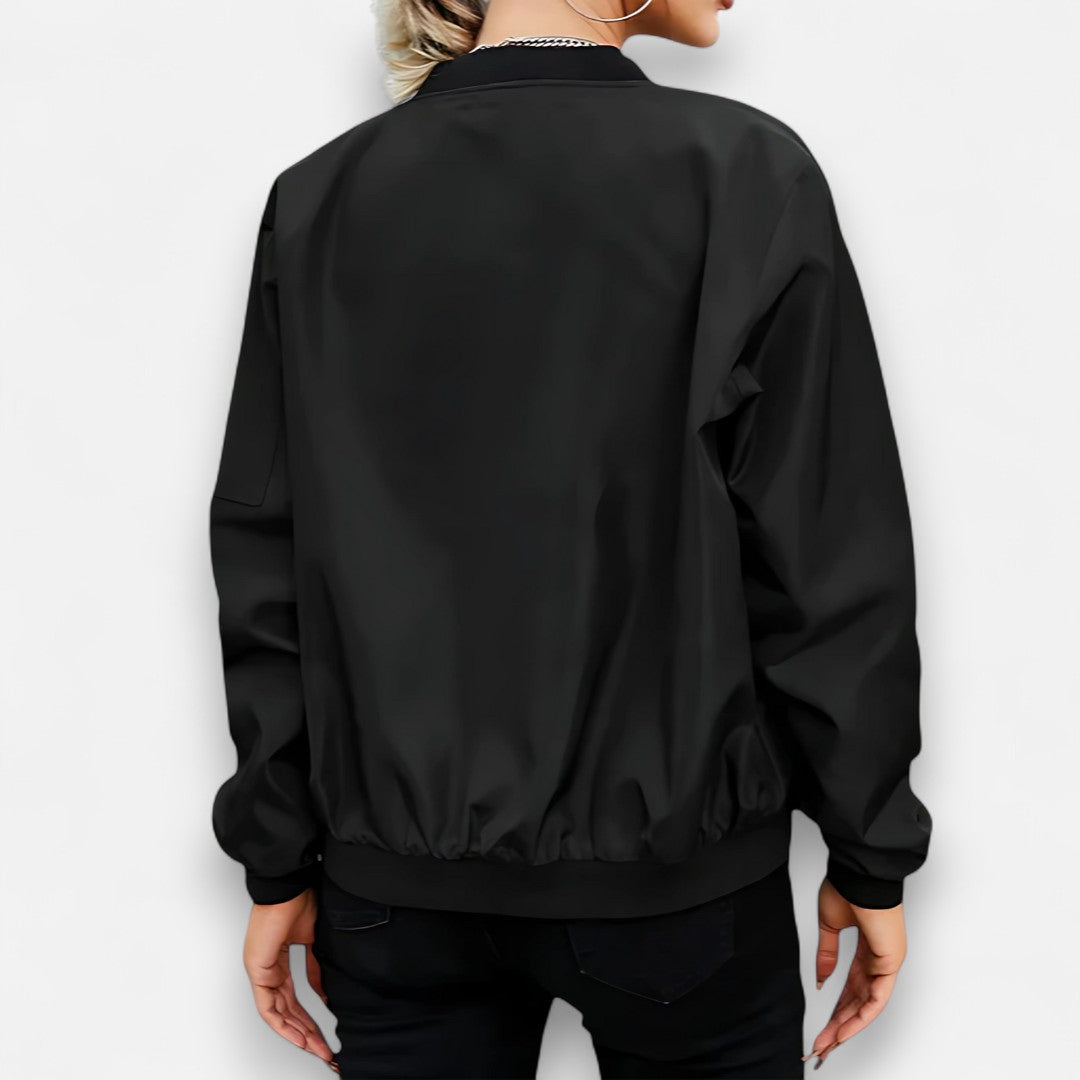 Black bomber jacket worn by a person on a white background