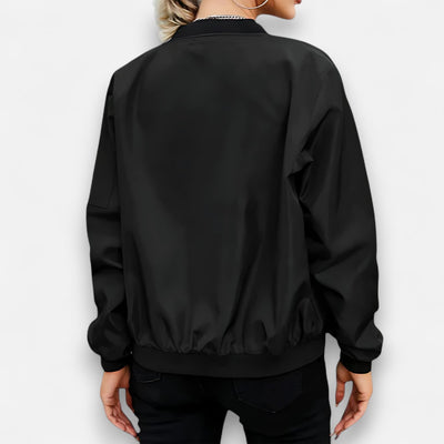 Black bomber jacket worn by a person on a white background